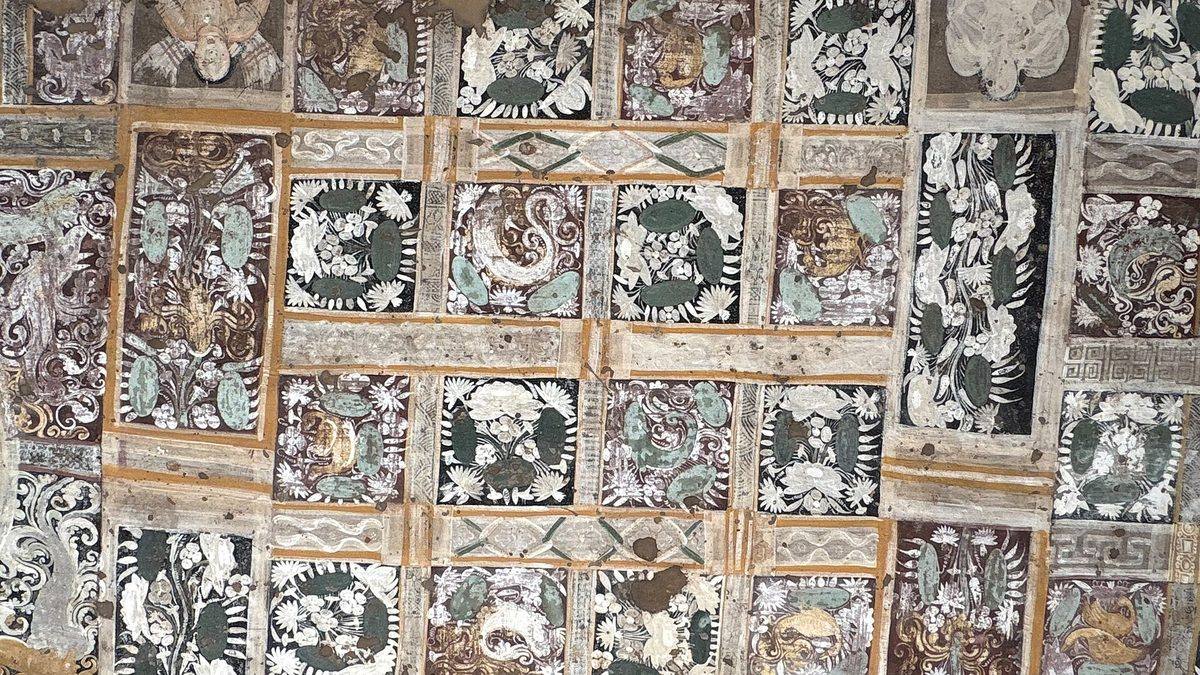 Painted mural panels on a ceiling at the Ajanta caves