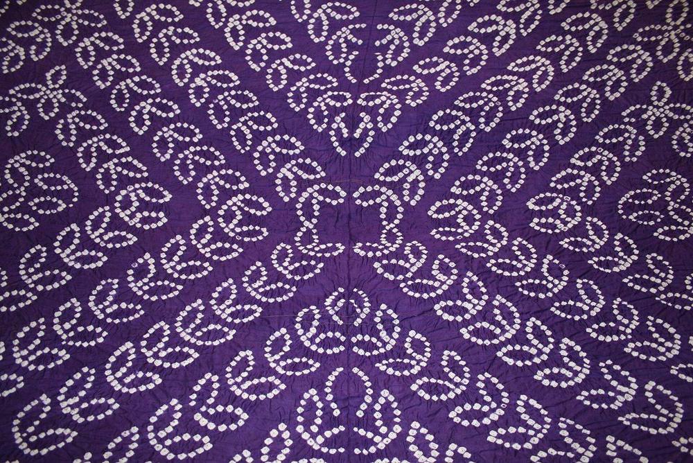 Purple Bandhani tie-dye fabric with fine white dot patterns