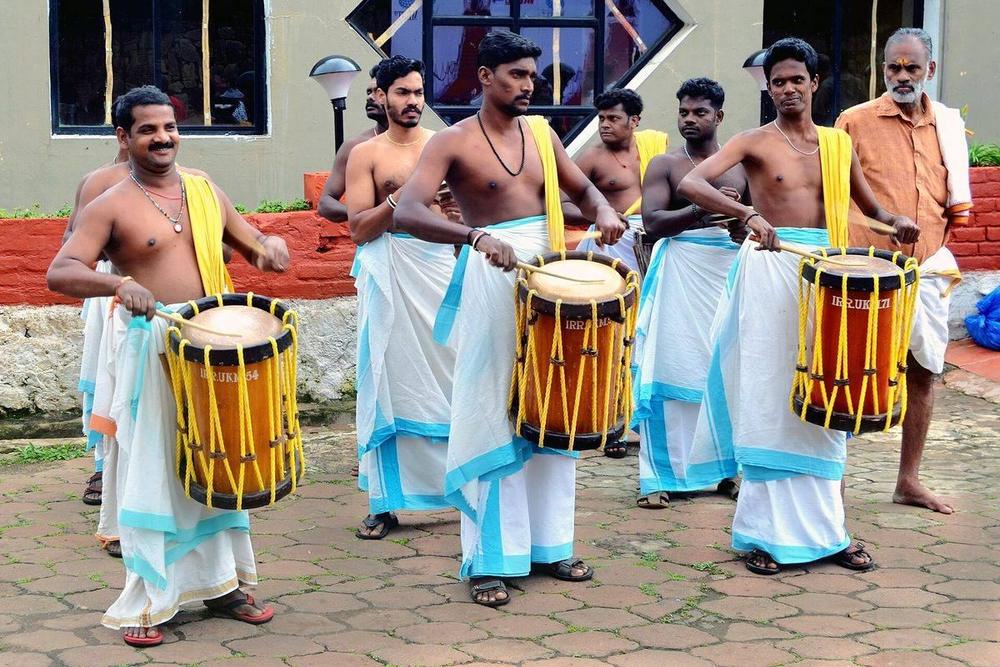 Chenda drummers in white mundu performing a chenda mela in Kerala