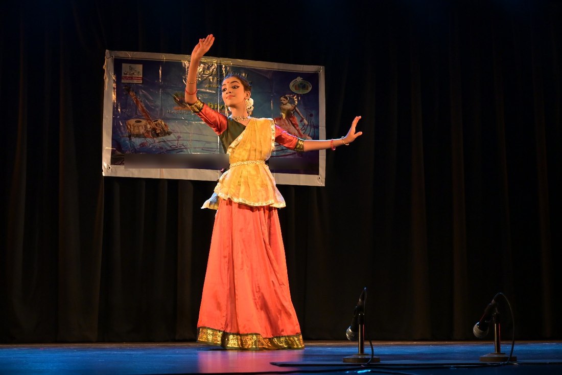 मंच पर कथक प्रस्तुति में देवांगी जन्मोह, भुजाएँ फैलाए एक सुंदर मुद्रा में