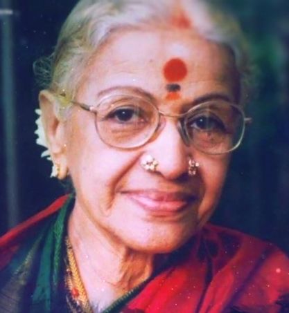 M. S. Subbulakshmi smiling, wearing a red sari