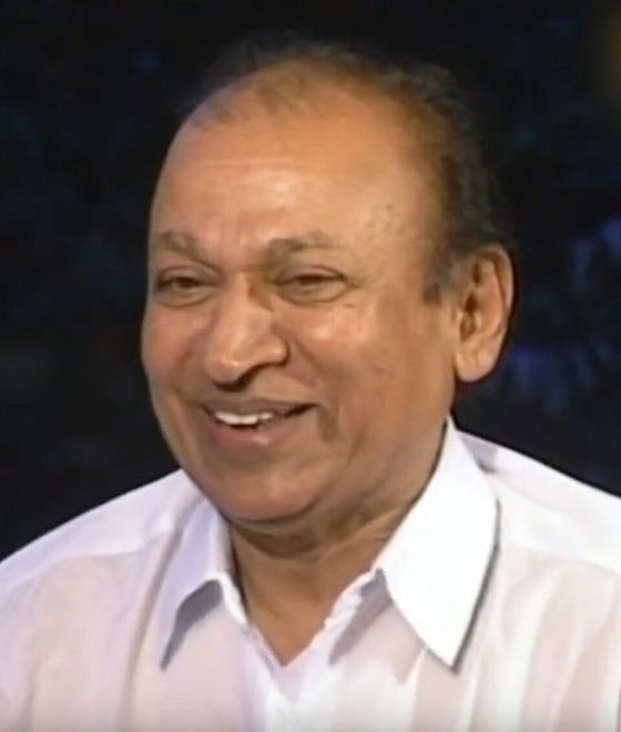 Dr. Rajkumar smiling, in a white shirt