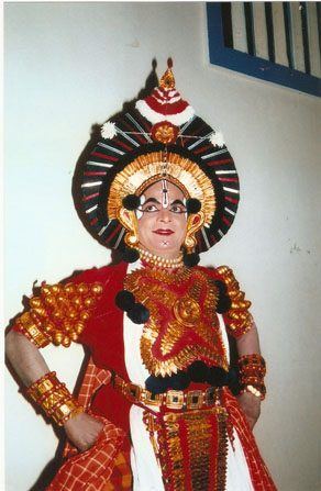 A Yakshagana performer in red costume and ornate headgear